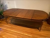 Front view of table fully extended with three leaves inserted