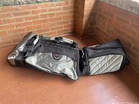 Side view of the soft sided golf travel bag showing grey and black fabric, handles, and strap details.