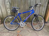 Full side view of blue Mongoose A40 mountain bike showing frame, tires, saddle, and handlebar.