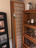 One set of three-panel folding screens with wood frame and white translucent paper grid panels, positioned near shelving unit.