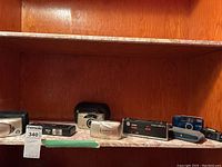 Overview of shelf displaying five point & shoot film cameras