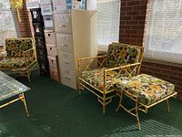 Two chairs and ottoman arranged together on green carpet near filing cabinets and window