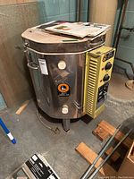 Front and side view of stainless steel kiln with manuals on top