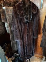 Front view of brown fur coat on hanger