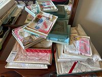 Overview of stacked decorative boxes containing assorted linens on dresser top