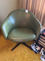 Front view of olive green vinyl chair showing bucket seat and integrated arms.