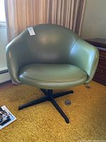 Front view of green vinyl swivel chair showing seat cushion and metal base