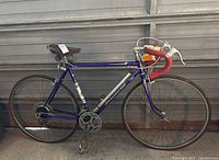 Side view of the full purple Peugeot road bike with drop handlebars, leather seat, and 10-speed drivetrain.