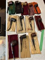 All 12 briar pipes laid out with cloth pouches