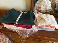 Overall view of two stacks of folded vintage sweaters