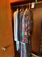 Overview of four garments hanging on a closet rod