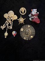 Full lot of vintage pins arranged on black background with quarter for size reference.