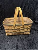 Front and side view of rectangular woven basket with two flat wood handles and plastic liner inside.