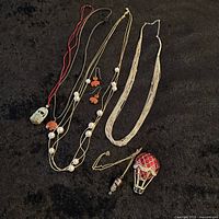 Full lot of vintage jewelry including necklaces, earrings, and pin on black background.