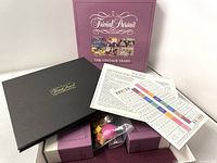 Contents including box insert, game pieces, dice, instruction sheets, and game cards displayed.