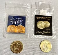 Two 24K clad tribute copy coins shown with their informational cards. Left is the 1795 $5 half eagle, right is the 1933 $20 gold coin tribute proof.
