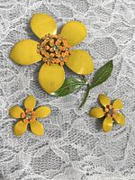 Full set of vintage yellow flower brooch and clip earrings on lace background