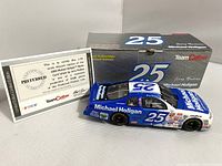 Blue 1:24 scale diecast model of the 2000 Michael Holigan Monte Carlo stock car number 25, driven by Jerry Nadeau, displayed next to its box and certificate of authenticity.