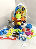 Mr. Potato Head main figure with face parts, accessories, and silly suitcase box in packaging shown
