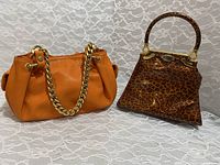 Both handbags shown side by side on lace background, highlighting size and color difference