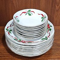 Stack of 8 salad bowls on top of 8 cereal bowls showing the Christmas holly and ribbon design.