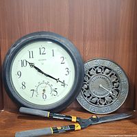 AcuRite atomic clock and Ivy outdoor thermometer with hedge shears in front