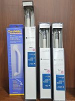 Photo showing one CareMate wall grab bar in retail packaging and three Glacier Bay 24" concealed polished chrome grab bars also in boxes.