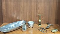 Photo showing the entire lot together with oblong dish, pitcher, bowl, corkscrew, brass shoe, and bangles.