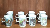Eight Dunoon fine bone china coffee/tea mugs arranged in two rows against a wood wall, each decorated with English cottage art.
