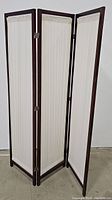 Full view of the 3-panel privacy screen standing upright showing frame and pleated fabric panels