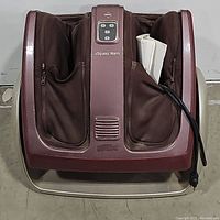 Top view of Osim uSqueeze Warm foot massager showing control panel and foot slots with soft fabric lining and attached power cord.