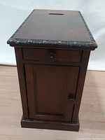 Front angled view showing drawer with carved hardware, cabinet door, and carved trim detailing on edges