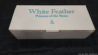 Closed white box labeled 'White Feather Princess of the Sioux' lettered in blue, indicating original packaging for the doll.
