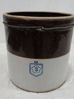Front view showing brown and white two-tone glaze with blue McCoy logo and number 3 mark on the crock.