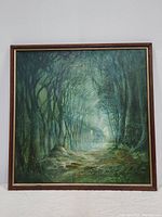 Full view of the framed oil painting showing the dark forest scene with tree canopy and mystic light effect.