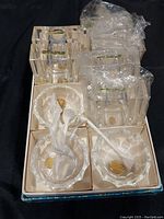 Boxed set containing two pairs of Lucite napkin ring holders with integrated salt and pepper shakers and four Bohemia glass salt cellars with gold labels inside and clear glass spoons.