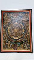 Full view of the Tibetan mandala artwork in a red and black wood frame.