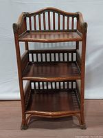 Front view of the vintage bamboo and rattan 3-tier shelf stand showing all three shelves and the bamboo frame.