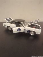 Side view showing white and blue Toronto Maple Leafs decals, black roof, open driver door and hood.