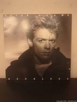 Front cover of Bryan Adams Reckless record album showing the artist's face in black and white portrait.