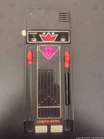 Top view of the handheld electronic bowling game powered on with pink LED lights in pin formation on the front panel, with sliding controls and buttons visible.