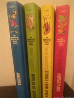 Photo showing spines of four hardcover Walt Disney books with colorful backgrounds and character illustrations, titles include America, Worlds of Nature, Stories From Other Lands, Fantasyland.