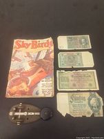 Photo showing all items including Sky Birds magazine, a Morse code key, and four German Reichsbanknotes