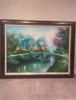 Framed painting of a house by a stone bridge over a body of water, showing the full artwork and frame.