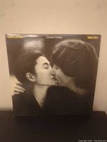 Front cover of Double Fantasy vinyl album showing John Lennon and Yoko Ono kissing in black and white.