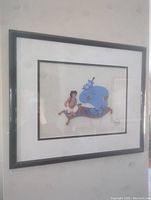 Framed serigraph cel of Aladdin and Genie on magic carpet hung on wall.