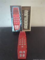 Merlin handheld game with original box showing front and interior containing device.