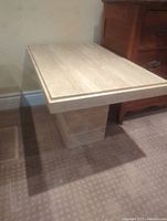 Side angle view of the rectangular travertine side table showing length and height