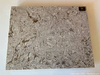 Full top view of the rectangular quartz cheeseboard showcasing overall grey and cream marbled pattern and original metal Cambria stamp in corner.