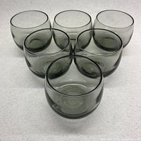 Front view of 5 smoky grey stackable lowball glasses arranged in a triangle pattern.